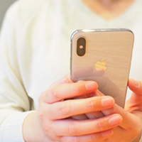 浮気を疑い携帯電話を見る女性